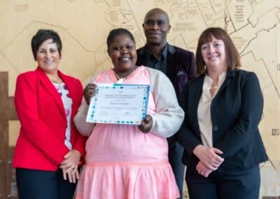 Graduation ceremony with smiling participants.