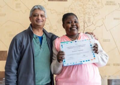 Smiling graduates holding a certificate.