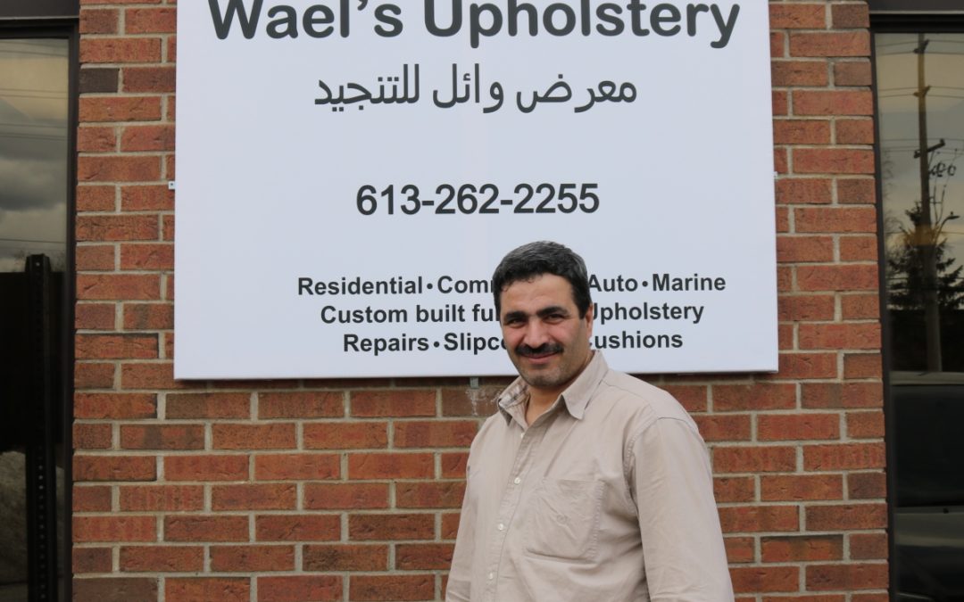 Wael standing in front of his furniture shop sign