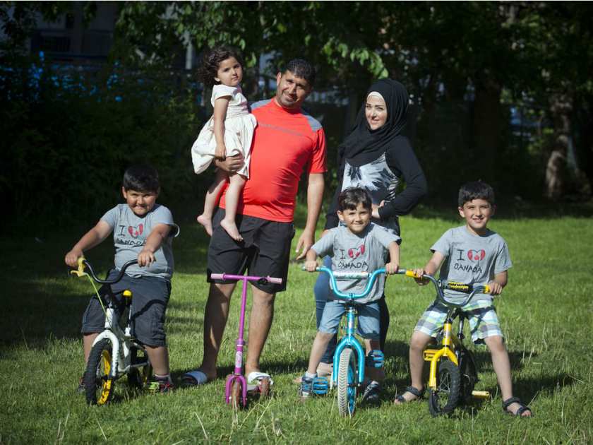 On the bikes, from left, Abdullah, 7, Lyana, 3, (in her dad's arms) Zeid, 5, and Mohamad, 7, with parents Jehad Alsebaee and Nirmeen Alsebai. This Syrian refugee family arrived in Ottawa just before Christmas 2015. ASHLEY FRASER / OTTAWA CITIZEN