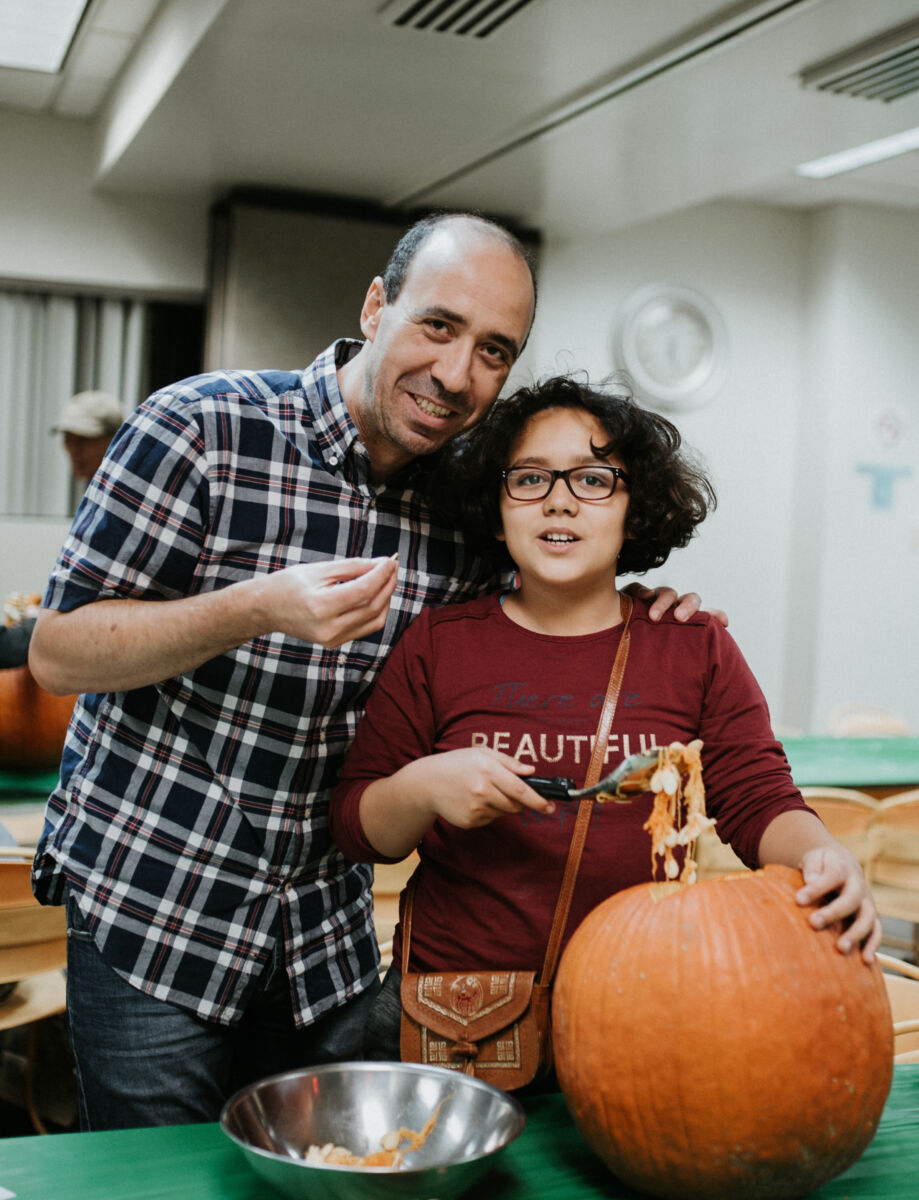 Father and daughter carve a pumpkin